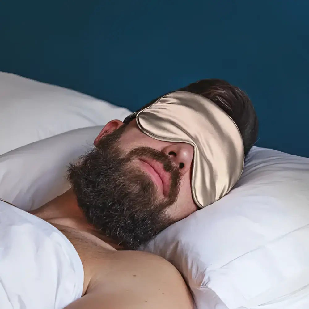 Beige Schlaf-Seidenmaske auf einem schlafenden Mann mit Augenschutz