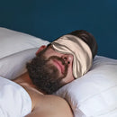 Beige Schlaf-Seidenmaske auf einem schlafenden Mann mit Augenschutz