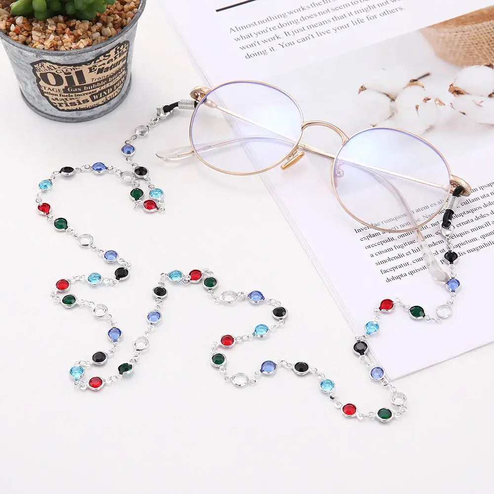 Runde Brillengläser mit buntem, mit Edelsteinen verziertem Kettenhalsband