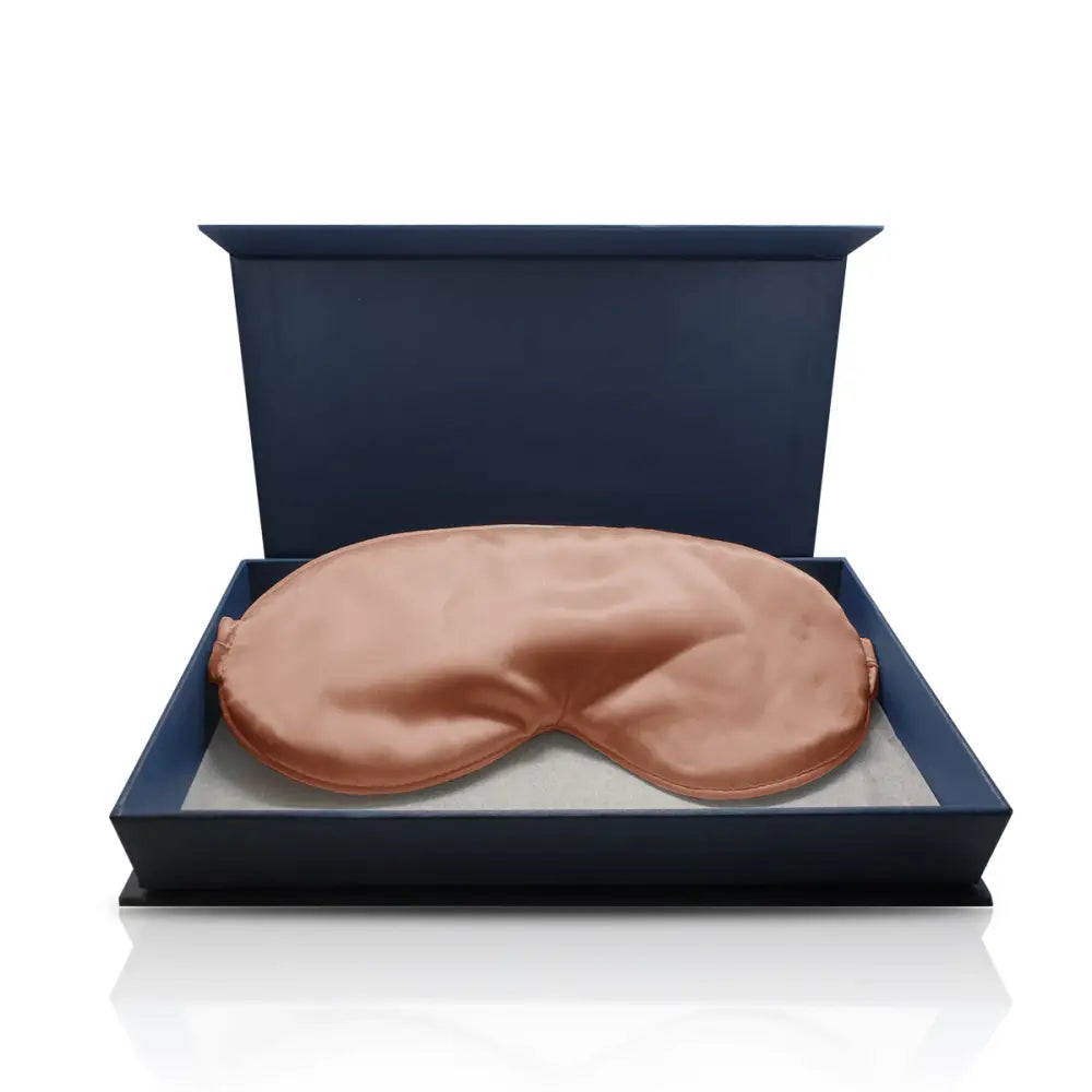 Peachfarbene Seidenschlafmaske in einer Navy-Box im Produkt Bronze Schlaf-Seidenmaske