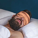 Schlafender Mann mit Bronze Schlaf-Seidenmaske für erholsamen Schlaf
