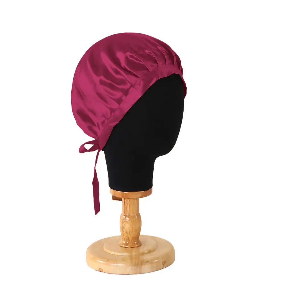 Burgunder Satin Haarbonnet auf einem Mannequin Kopf als Produkt Burgund Seidenhaube mit Bändern