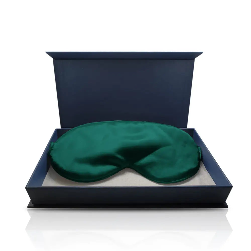 Emeraldgrüne Seiden-Schlafmaske in einer blauen Schachtel mit Produktname Dunkelgrüne Schlaf-Seidenmaske