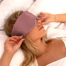 Frau trägt eine mauve Schlafmaske aus Seide aus der Dunkelrosa Schlaf-Seidenmaske Produktlinie