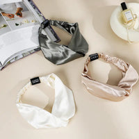 Drei Satin-Headbands auf Blau Elegantes Seidenstirnband Produktdisplay