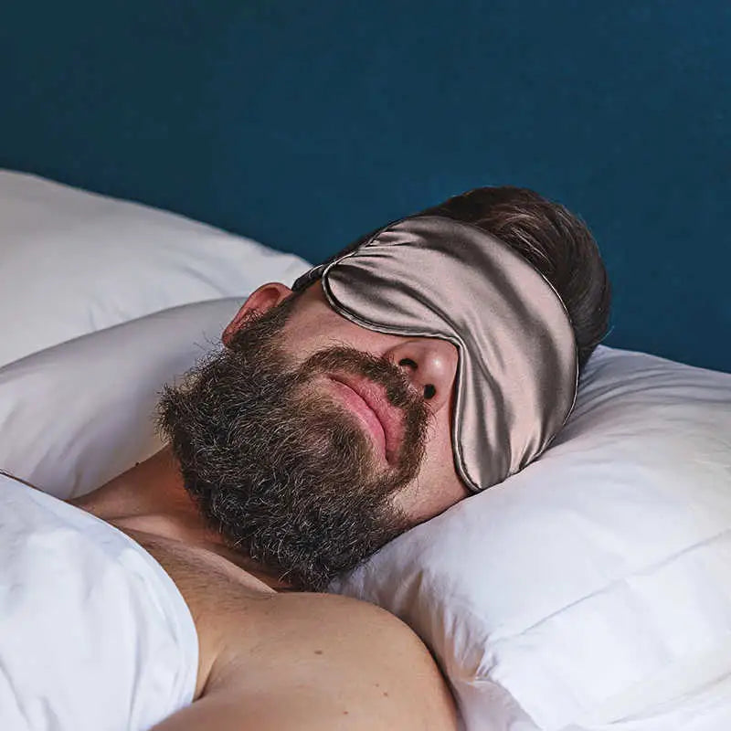 Bearded man trägt eine Graue Schlaf-Seidenmaske für erholsamen Schlaf