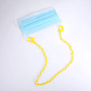 Blaue OP-Maske mit gelbem Kettenhalsband als modisches Accessoire