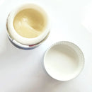 Offene Dose Gelbe Creme PEEL DUO auf weißem Hintergrund