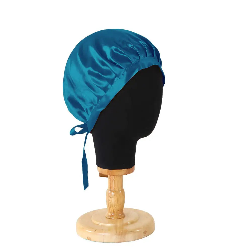 Pfauenblaue Seidenhaube mit Bändern auf einem Modellkopf, Teal Satin Haarbonnet