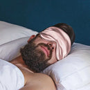 Schlafender Mann mit Rosa Schlaf-Seidenmaske für erholsamen Schlaf