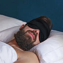 Schwarze Schlaf-Seidenmaske auf schlafendem Mann mit Augenmaske in ruhigem Schlaf