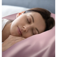 Schlafende Frau auf Rose Pink Seidenkissenbezug in elegantem Schlafzimmer