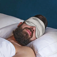 Schlafender Mann mit Weisse Schlaf-Seidenmaske in dunklem Raum