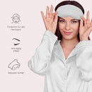 Frau mit weißer Schlaf-Seidenmaske und Pyjamas für perfekten Schlaf